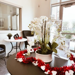 Love is in the air at Quadrangles on Twenty! red lei with paper hearts around a potted orchid